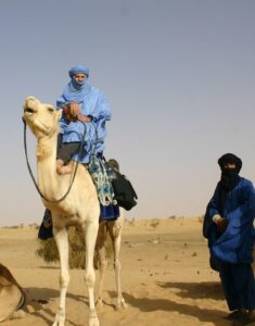 Mali tuareg author mounted on camel in sahara